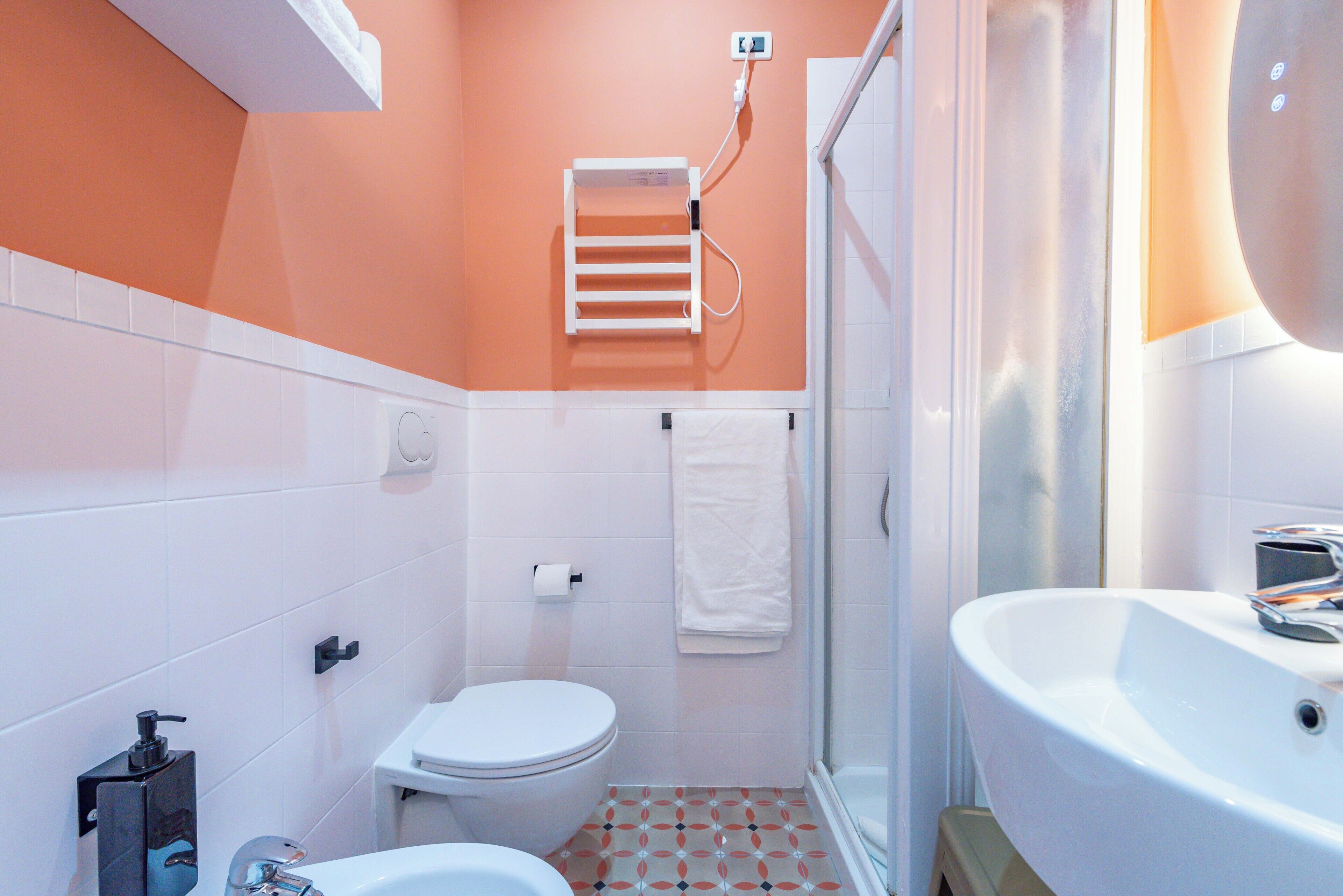 A bathroom with a toilet, sink, and shower.
