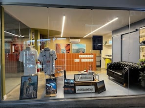 A hotel lobby with a reception desk, framed pictures on the wall, and a black leather sofa. - 3003B (São Paulo)