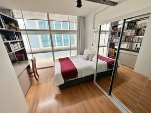 A modern bedroom with a large bed, a desk, and a bookshelf. - 1416B (São Paulo)