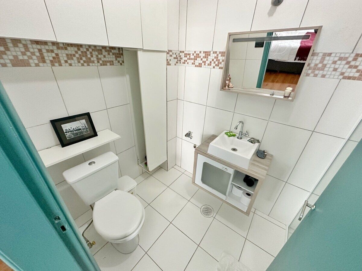 A bathroom with a toilet, sink, and mirror.