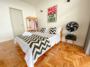A bedroom with a bed, a wooden wardrobe, a wall-mounted fan, and a motivational poster. - 2919B (São Paulo)