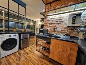 A modern kitchen with a brick wall, stainless steel appliances, and a large window. - 2716B (São Paulo)
