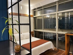 A modern bedroom with a large window, a bed with white bedding, and a wooden floor. - 2716B (São Paulo)