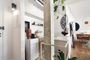 A modern kitchen with white cabinetry, a coffee machine, and a hanging plant. - 3217B (São Paulo)