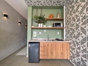 Una cucina compatta con lavastoviglie integrata, forno a microonde e piano cottura a gas.