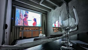 Una habitación de hotel con cama, televisión y una copa de vino.