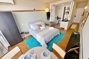 Ett modernt hotellrum med en säng, ett skrivbord och en matplats.