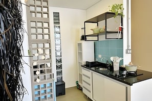 Eine moderne Küche mit weißen Schränken, einer schwarzen Arbeitsplatte und einer blauen Spritzschutzwand.