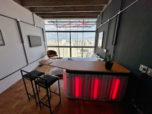 A modern office space with a large window, a desk, two chairs, and a bed. - 2609B (São Paulo)
