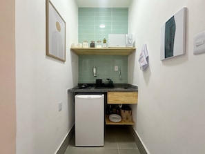 A compact kitchen with a refrigerator, a sink, and a countertop. - 2606B (São Paulo)