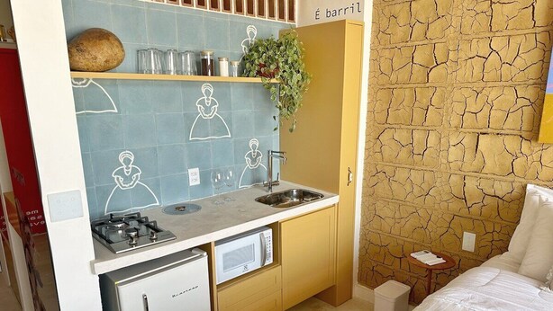 Une petite cuisine équipée d’un four à micro-ondes, d’un évier et d’un petit réfrigérateur.