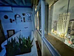 A narrow balcony with a cityscape view, a small plant, and wall-mounted items. - 2315B (São Paulo)