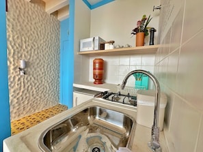 A kitchen with a stainless steel sink, a microwave, and a gas stove. - 2315B (São Paulo)