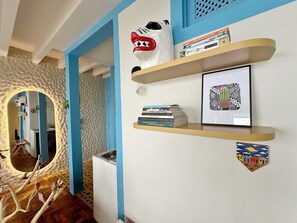 A hallway with a mirror, bookshelves, and a cactus artwork. - 2315B (São Paulo)