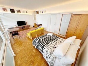 A room with a bed, a desk, a chair, a television, and a wardrobe. - 0517B (São Paulo)