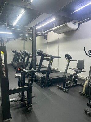 A gym with treadmills, elliptical machines, and weightlifting equipment. - 0517B (São Paulo)