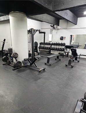 A gym with weightlifting equipment, benches, and dumbbells. - 1704B (São Paulo)