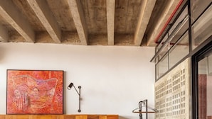 A bedroom with a wooden headboard, a bed with white bedding, a floor lamp, and a large abstract painting. - 3220B (São Paulo)