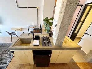Una cocina equipada con estufa a gas, lavaplatos y lavamanos.