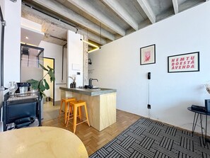 Una cocina moderna con una isla central, taburetes de madera y un tapete estampado.
