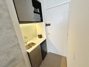 A compact bathroom with a sink, mirror, and storage cabinet. - 0713B (São Paulo)