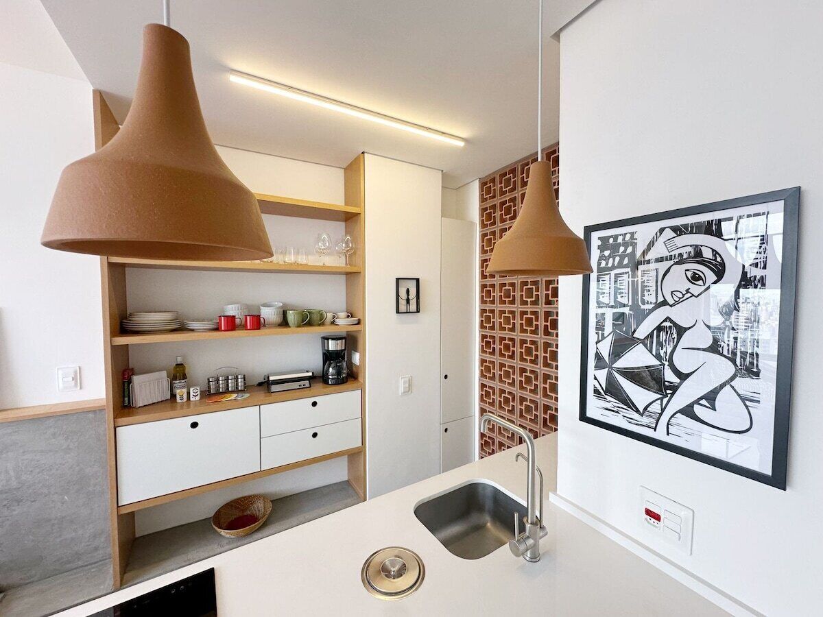 Eine moderne Küche mit Einbauofen, Spüle und einer Arbeitsplatte mit Kaffeemaschine.