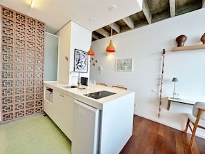 A modern kitchen with a white island, pendant lights, and a wooden floor. - 3009B (São Paulo)