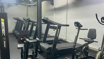 A gym with treadmills, elliptical machines, and weightlifting equipment.
