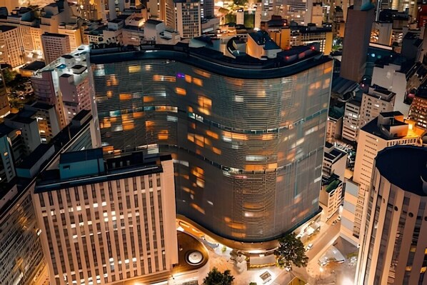 A modern building with a curved facade, surrounded by other high-rise buildings.