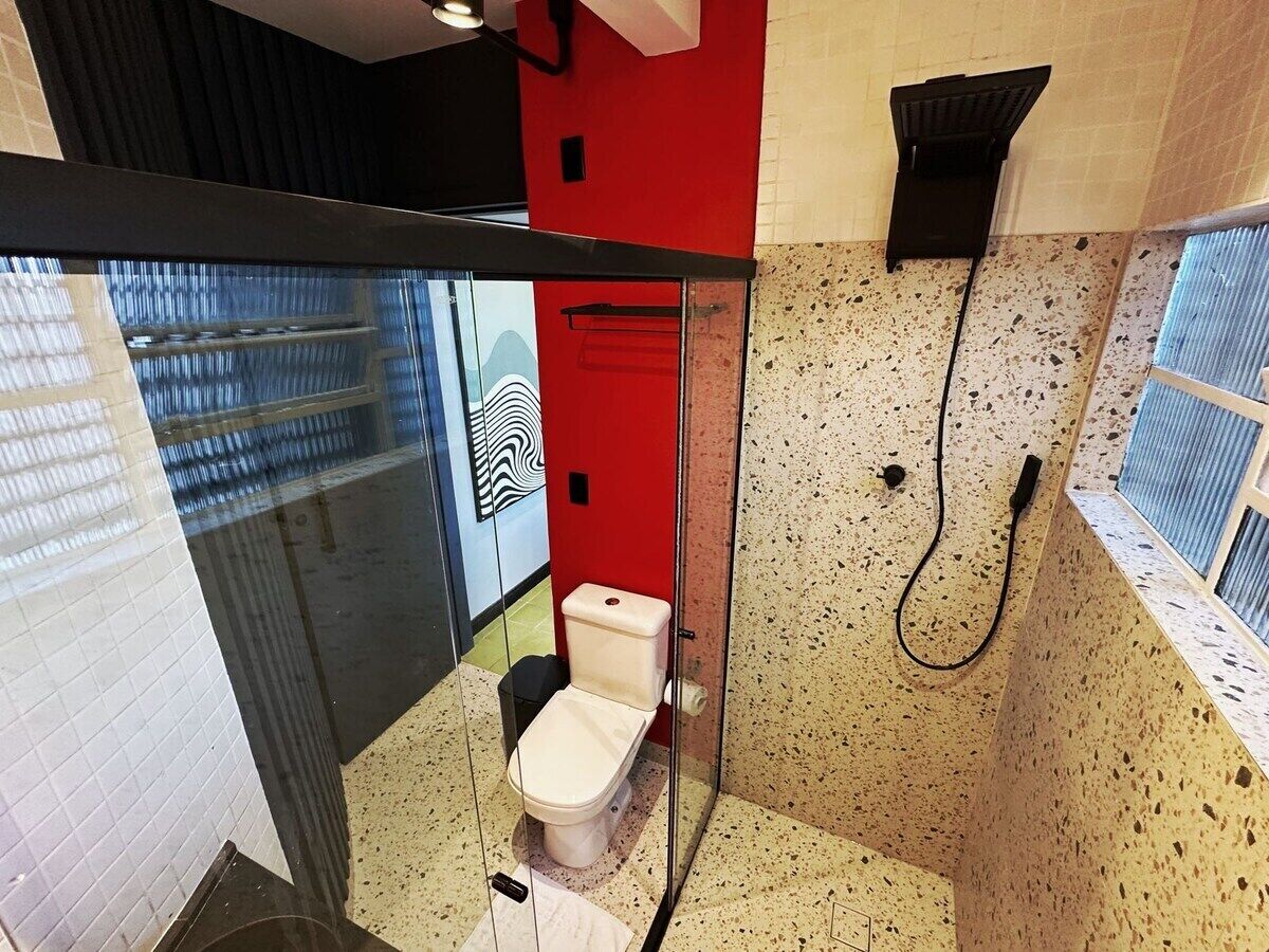 Ein Badezimmer mit Toilette, Dusche und einer Glasabtrennung.