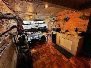 A kitchen with a herringbone floor pattern, a brick wall, and a window overlooking a cityscape. - 3013M (São Paulo)