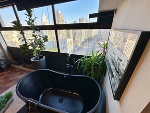 A modern bathroom with a freestanding bathtub, large windows, and potted plants. - 3013M (São Paulo)