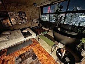 A room with a bed, a desk, a chair, and a large window with a city view. - 3013M (São Paulo)