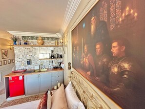 A hotel room with a bed, a painting, a kitchenette, and a red refrigerator. - 2312B (São Paulo)
