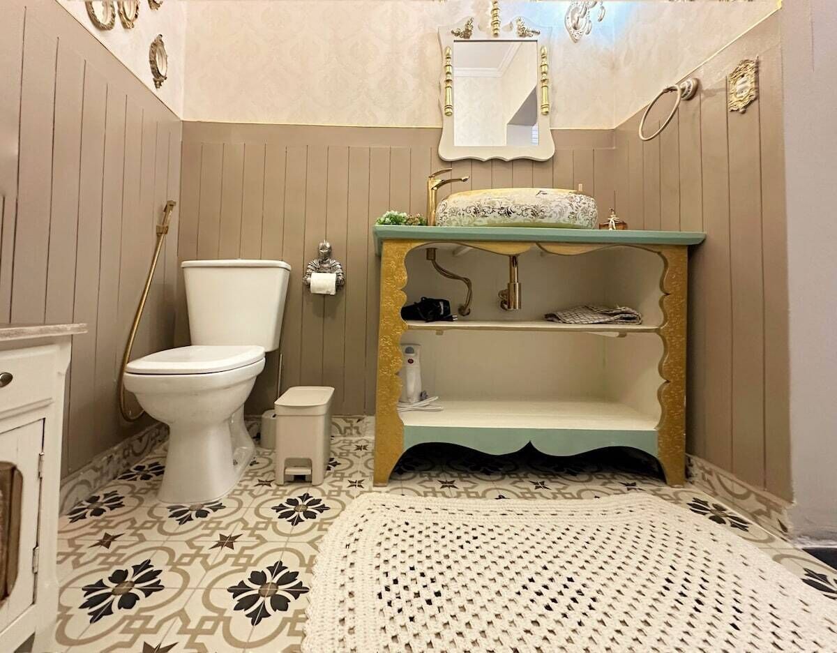 Een badkamer met toilet, wastafel en badkamermeubel.