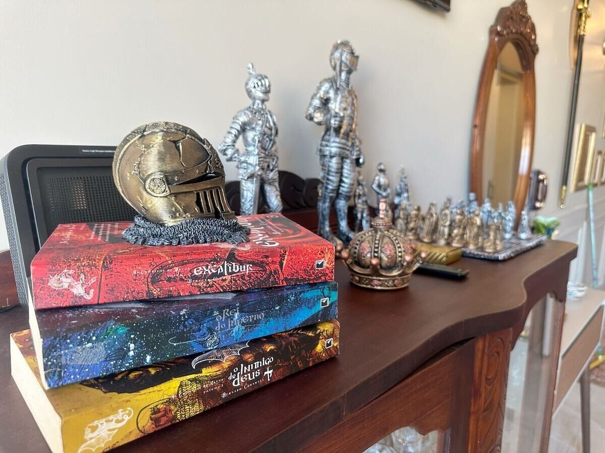 A wooden desk with a stack of books, a globe, and decorative items.