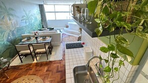 A modern kitchen with a dining area, a herringbone floor pattern, and a large green plant. - 2815M (São Paulo)