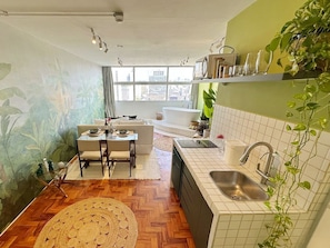 A compact kitchen with a dining area, a built-in oven, and a window with a city view. - 2815M (São Paulo)