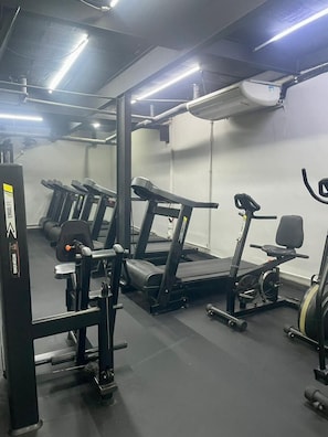 A gym with treadmills, a stationary bike, and weightlifting equipment. - 2011B (São Paulo)