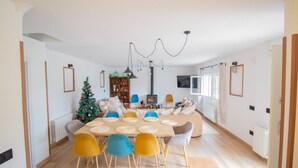 Una sala moderna con comedor, chimenea y un árbol de Navidad.