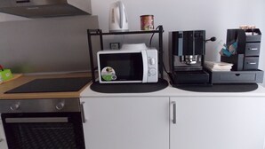 A compact kitchenette with a microwave, coffee maker, and a small oven. - Central Palace (Reggio Calabria)