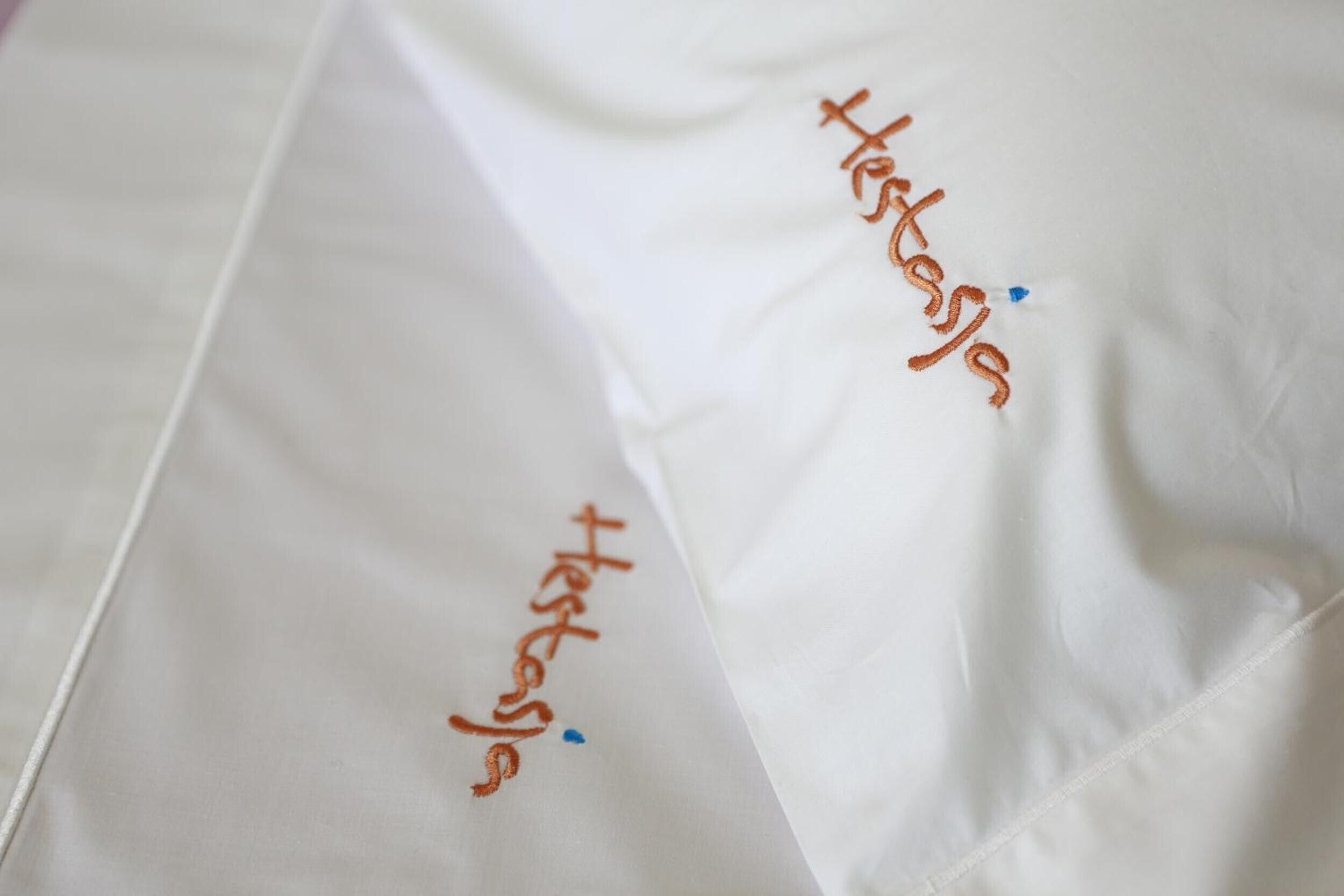 Tecido branco com texto bordado.