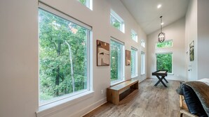 A spacious room with large windows, a pool table, and a bench. - StayHocha Luxury Pet Friendly Cabin (Broken Bow)