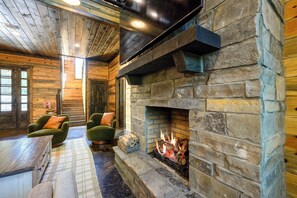 A cozy interior with a stone fireplace, wooden walls, and comfortable seating. - Luxurious 4 Bedroom Cabin Retreat in Broken Bow (Broken Bow)