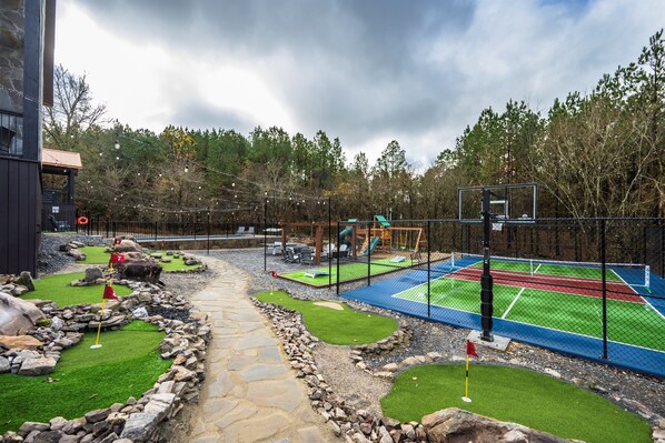 Um campo de golfe com putting green, armadilhas de areia e driving range.