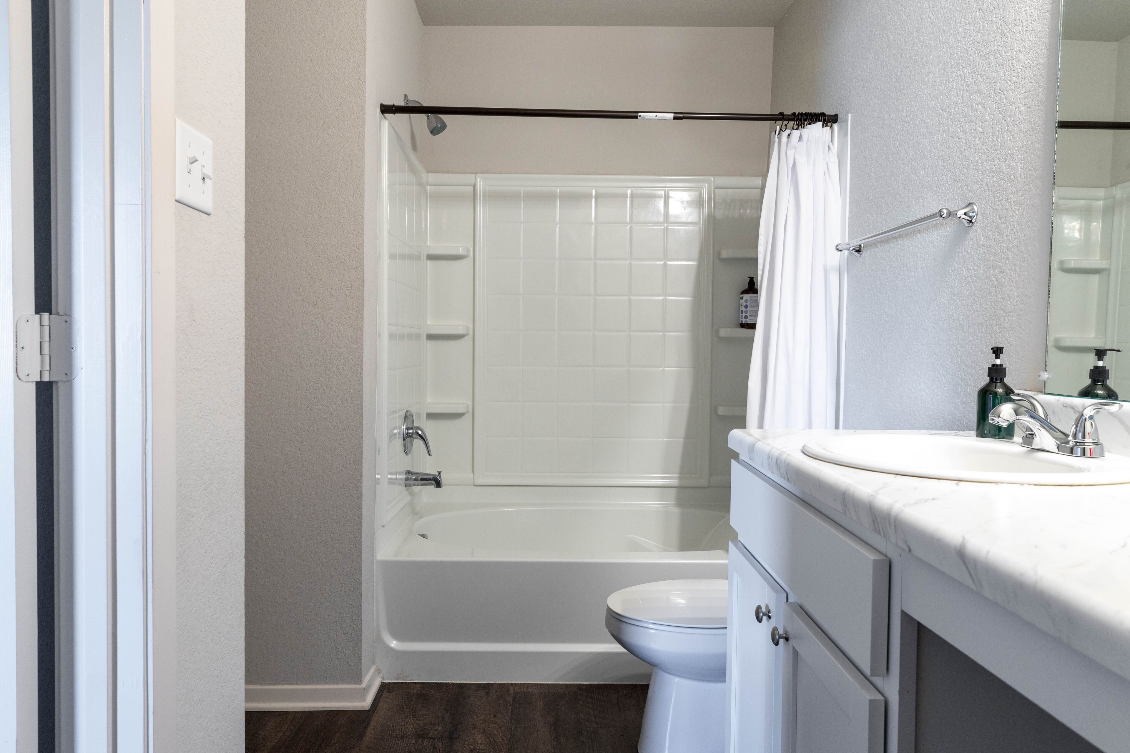 A modern bathroom with a bathtub, toilet, and sink.