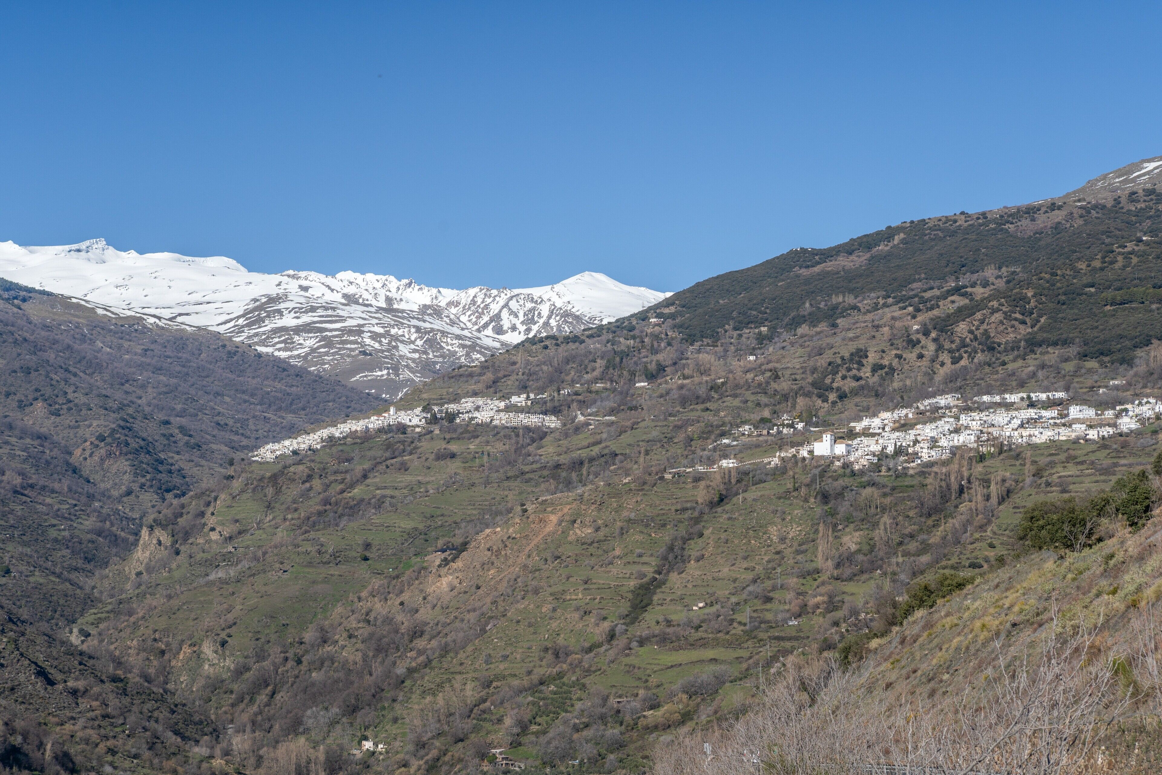 Un paysage montagneux avec un village niché au fond de la vallée.