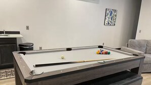 A pool table in a modern living room with a sofa and a painting on the wall. - Food Truck Court BNB w/breakfast & pool table (Carlsbad)