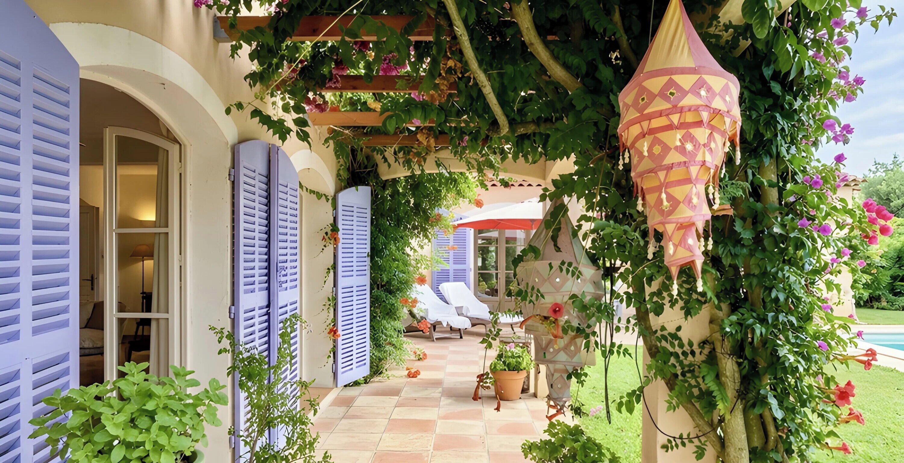 Un espacio al aire libre cubierto con una pérgola, plantas en macetas y un farol colgante.