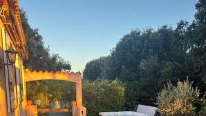 Ein Patio mit gefliestem Boden, einem Whirlpool und einer Pergola.